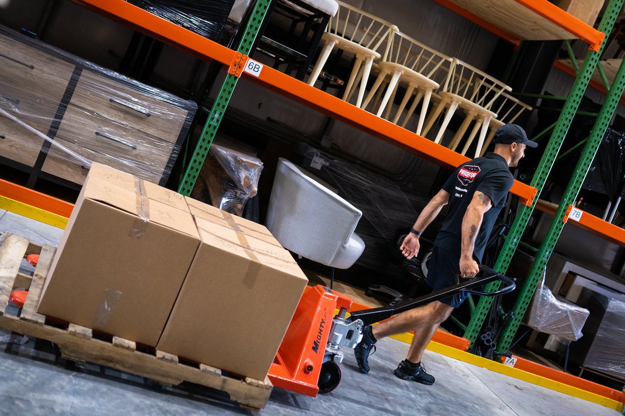 Warehouse worker moving a pallet of boxes