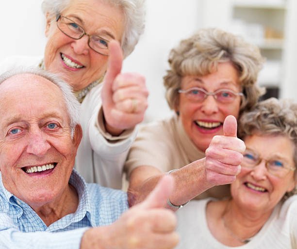 Happy seniors giving a thumbs up after a move