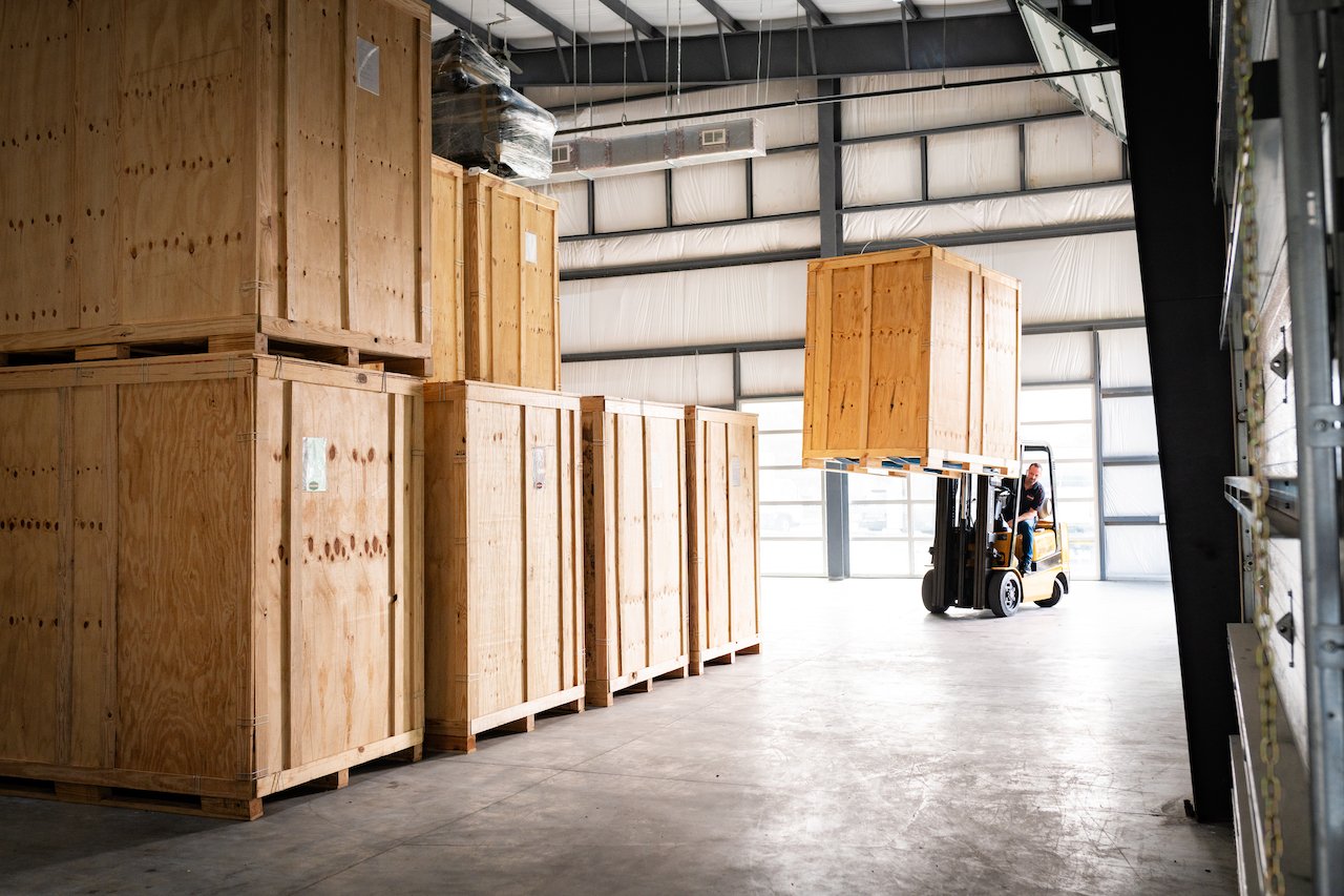 Forklift operator lifting a wooden crate
